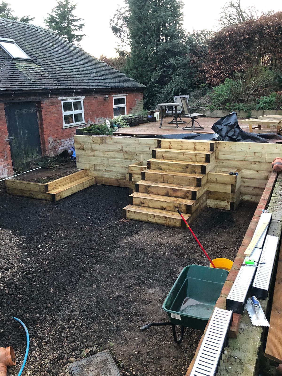 Garden construction scene with timber edging and groundwork in progress