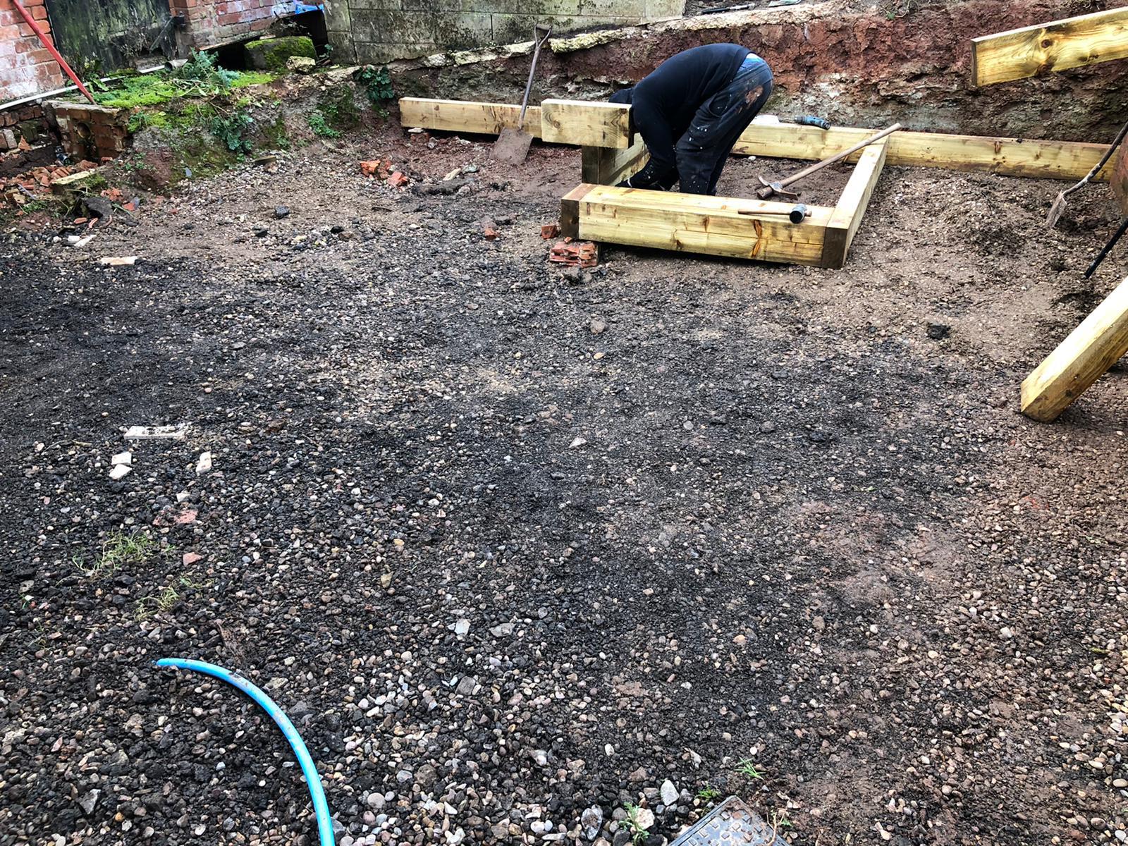 Groundwork and gravel base preparation with tools visible