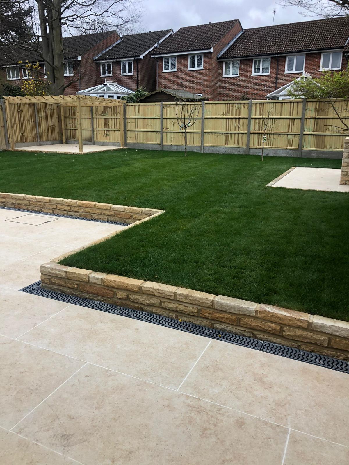 Finished landscaped garden with paved patio sections, raised timber edging and lawn
